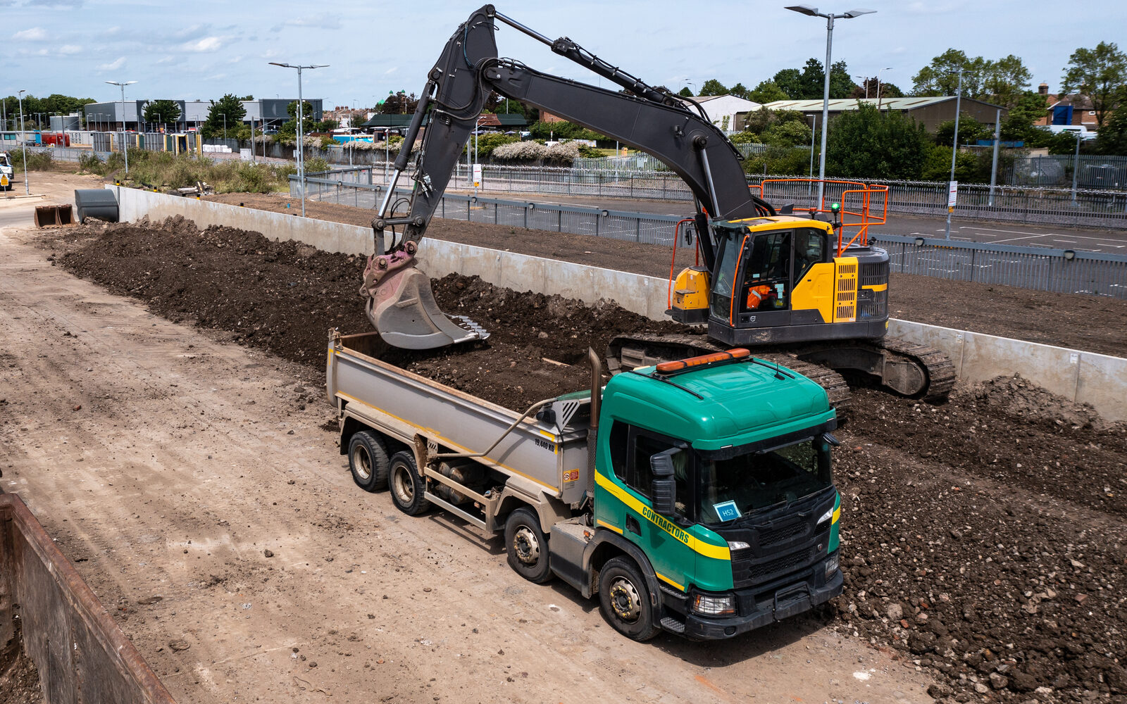 Excavator loading a construction vehicle